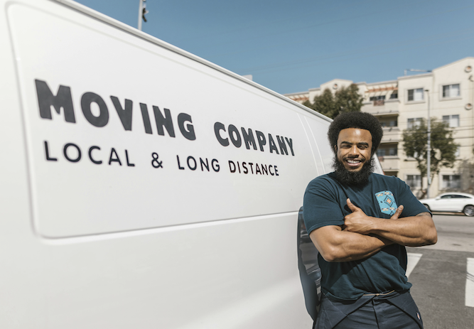 A man leans against his moving van, helping someone move stress-free